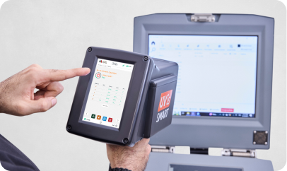 Hand holding OES instrument near monitor